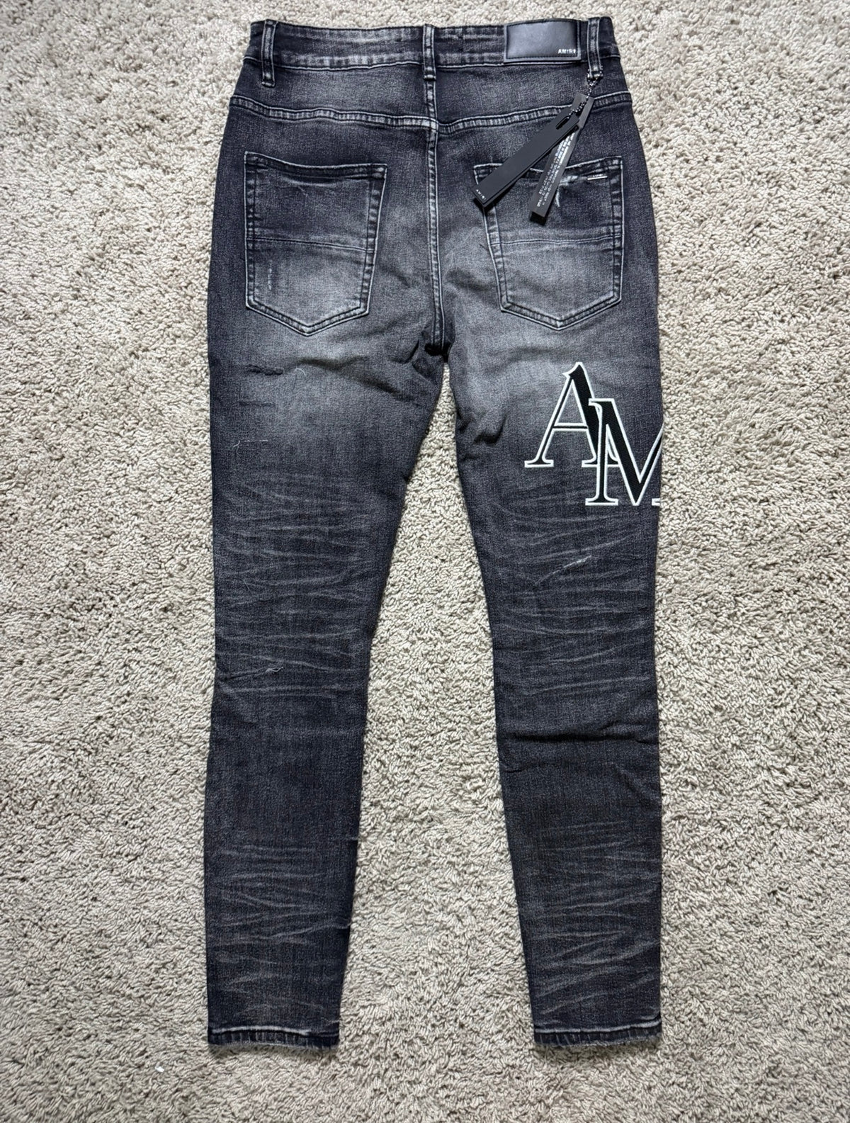Amiri black/grey staggered letter jeans