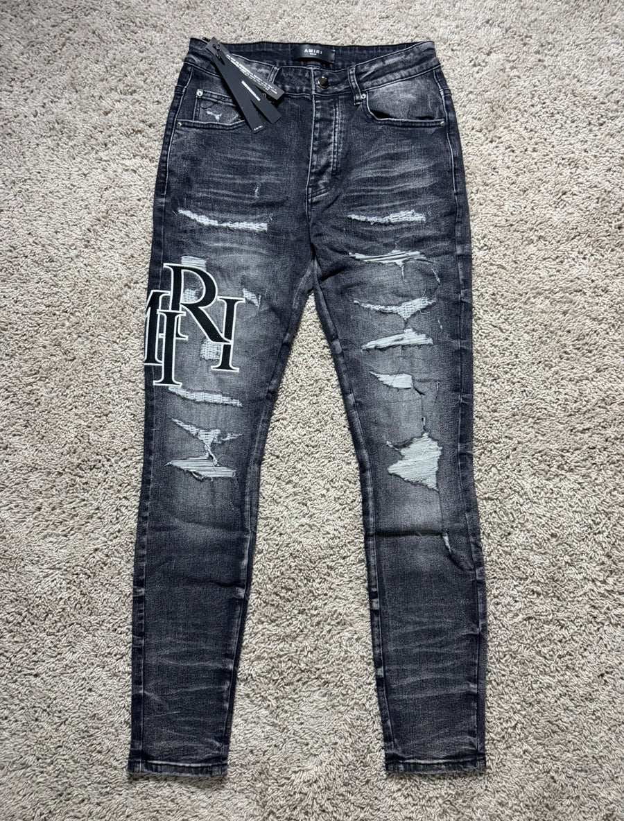 Amiri black/grey staggered letter jeans